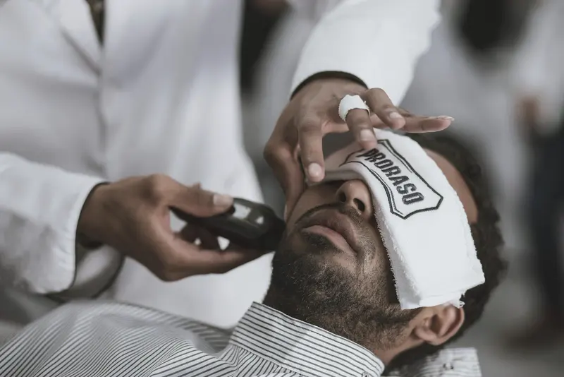 Barbier führt Rasiermesser und Kamm am Hinterkopf