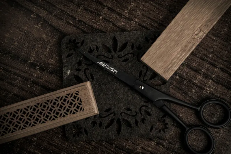 Schwarze Friseurschere auf dunklem Holz